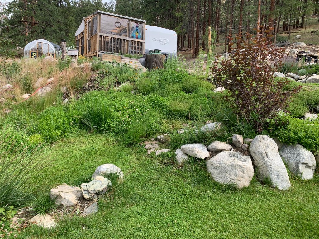 Open Range trailer, screened porch, greenhouse, and terraced garden on the hillside
